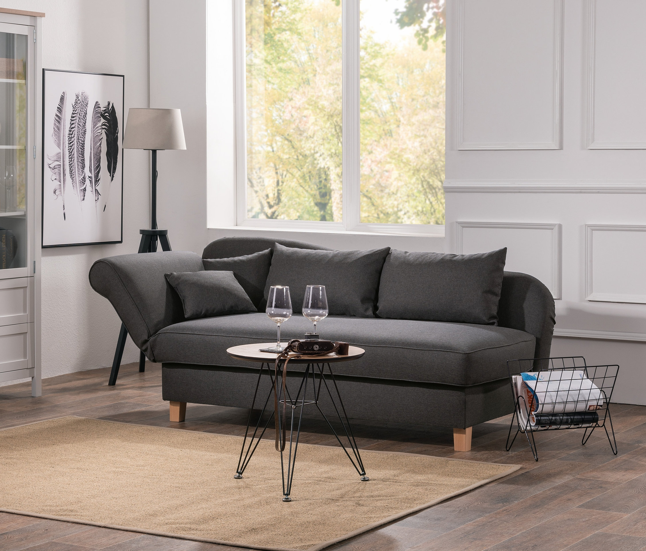 Wohnzimmer mit grauer Max-Winzer®-Recamiere »Saturn« mit Stauraum, Glasvitrine und Couchtisch auf beigem Teppich.