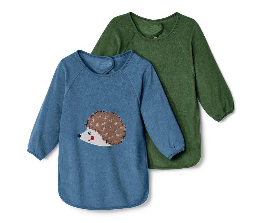 Zwei Baby-Ärmellätzchen: Einer blau mit Igel-Applikation, einer grün.
