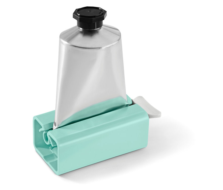 Silberne Tube mit schwarzem Verschluss in einem türkisfarbenen Tubenausdrücker.