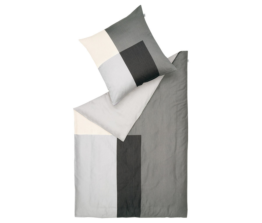 Draufsicht einer Bettwäschegarnitur mit geometrischem Muster in Grau- und Weißtönen.