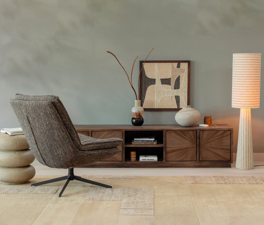 Einrichtungsszene mit einem grauen Sessel auf einem sandfarbenen WOOOD Handwebteppich »Noven«, 170 x 240 cm.