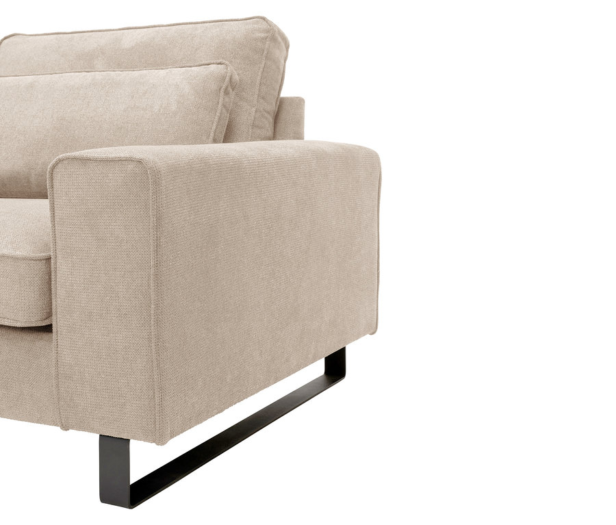 Detailaufnahme eines beigen Sessels mit schwarzen Metallbeinen.