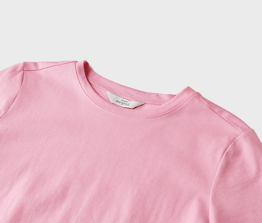 Nahaufnahme eines hellrosa T-Shirts mit Rundhalsausschnitt und einem weißen Etikett mit der Aufschrift "Tchibo My Style".