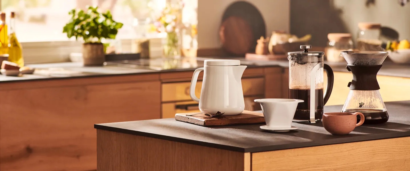 Ein kleiner Junge schaut zu, wie ein Kaffee mit einem Keramikfilter in eine Glaskanne aufgebrüht wird. Das ist die Schwerpunkt Seite der Manuellen Zubereitung.