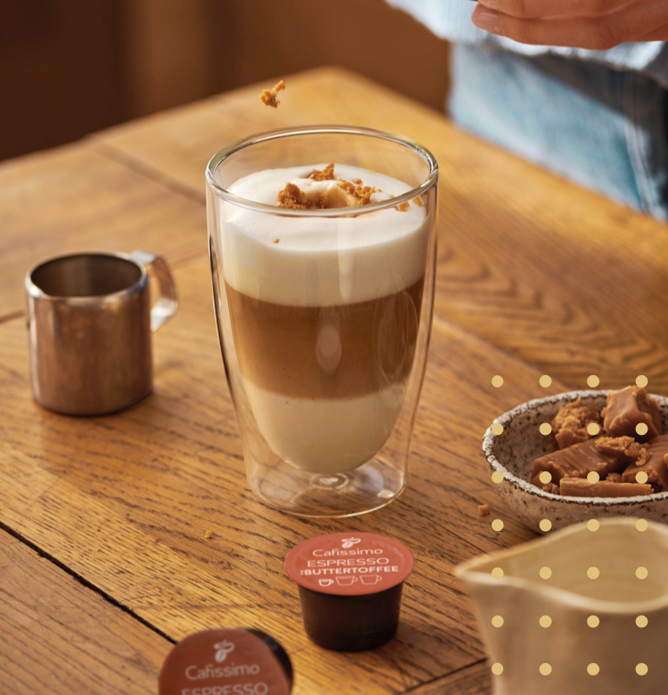 Eine Frau garniert einen Barraquito mit Toffee-Stückchen
