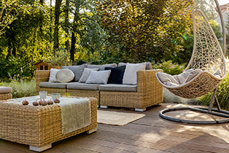 Hochwertige Verarbeitung bei Ihren Gartenmöbeln: Eine Holzterrasse mit Loungemöbeln und einem freischwingenden Relax-Sessel.