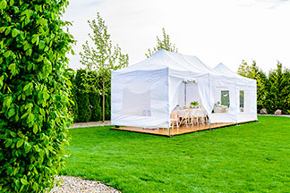 Auf die Größe achten: Ein weißer Pavillon, der dich mitten im Aufbau befindet, steht auf einer grünen Wiese im Garten.