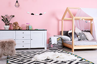 Einsatz auch im Kinderzimmer: Ein weißes Sideboard in einem Mädchen-Kinderzimmer mit rosafarbener Wand.