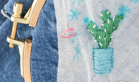 Blütenmuster werden in eine Jeans gestickt