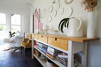 Flexibles Raumwunder: Ein Sideboard mit Holz-Schubladen und offenen Regalböden, in denen zahlreiche Bücher liegen.