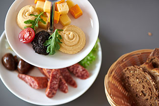 Hübsch und praktisch: Étagère auf einem Esstisch mit Wurst und Käsestückchen.