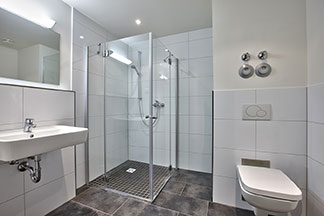 Zeitloser Chic: Badezimmer mit einer Eckdusche aus Glas.