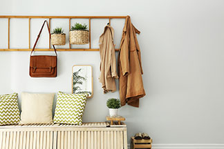 Die richtige Garderobe für den Flur: Ein schmaler Flurbereich mit Holzboden und weißen Wänden an dessen Ende ein weißer Garderobenschrank steht.