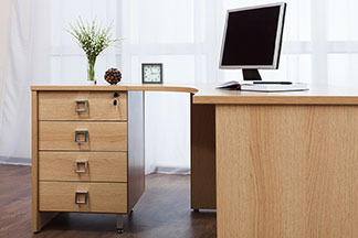 Platzsparende Alternative zum Büroschrank: Schreibtisch mit Schubladenunterschrank, ein Fach ist abschließbar.
