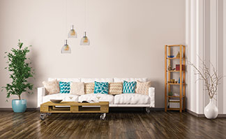 Funktionaler Hingucker: Eine Couch mit bunten Kissen und einem rechteckigen Paletten-Couchtisch auf Rollen.