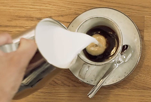 Milch wird über den Espresso gegossen