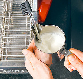 Dampfdüse in die Milch eintauchen
