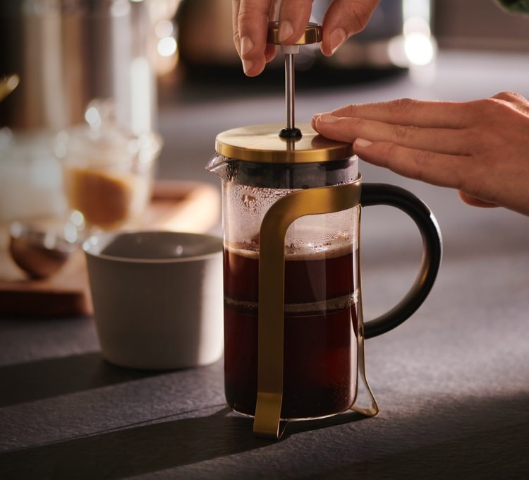 Stimmungsvolles Bild der manuellen Zubereitung mit einer Siebstempelkanne. Denn von Siebstempelkanne über Porzellan-Kaffeebereiter bis zu Pour Over, ist hier für jeden etwas dabei.