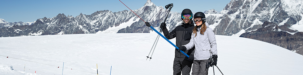 Frau und Mann auf einem Ankerlift beim Skifahren
