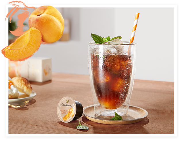 Ein zubereiteter Apricot-Mint Coffee on Ice angerichtet in einem Latte Macchiato Glas