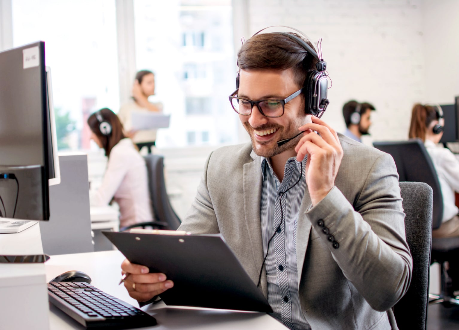 Ein Servicemitarbeiter sitzt am Telefon und beantowrtet Fragen.