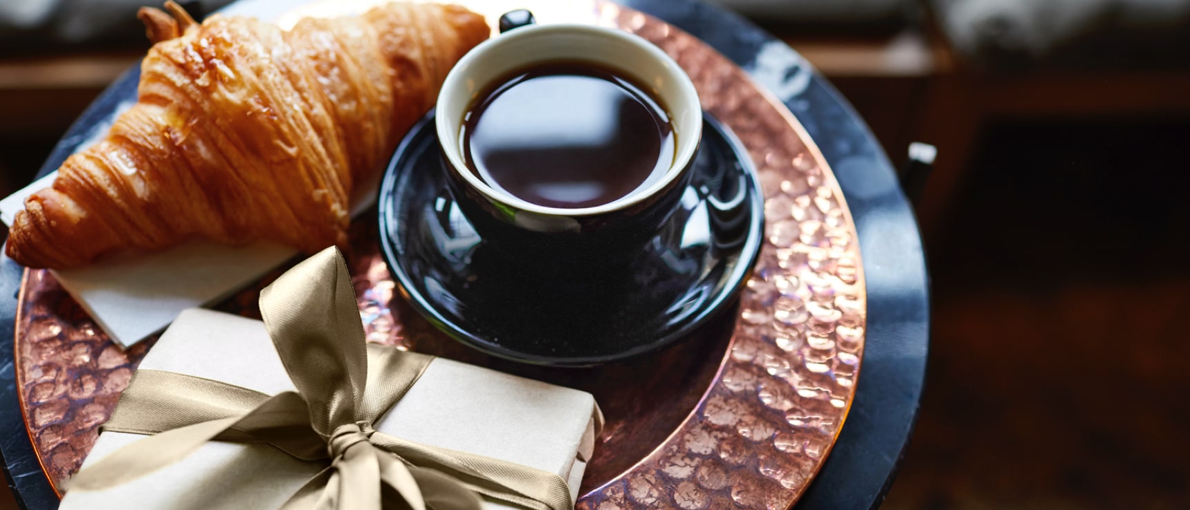 Glas Kaffee steht mit Geschenk auf einem Tisch