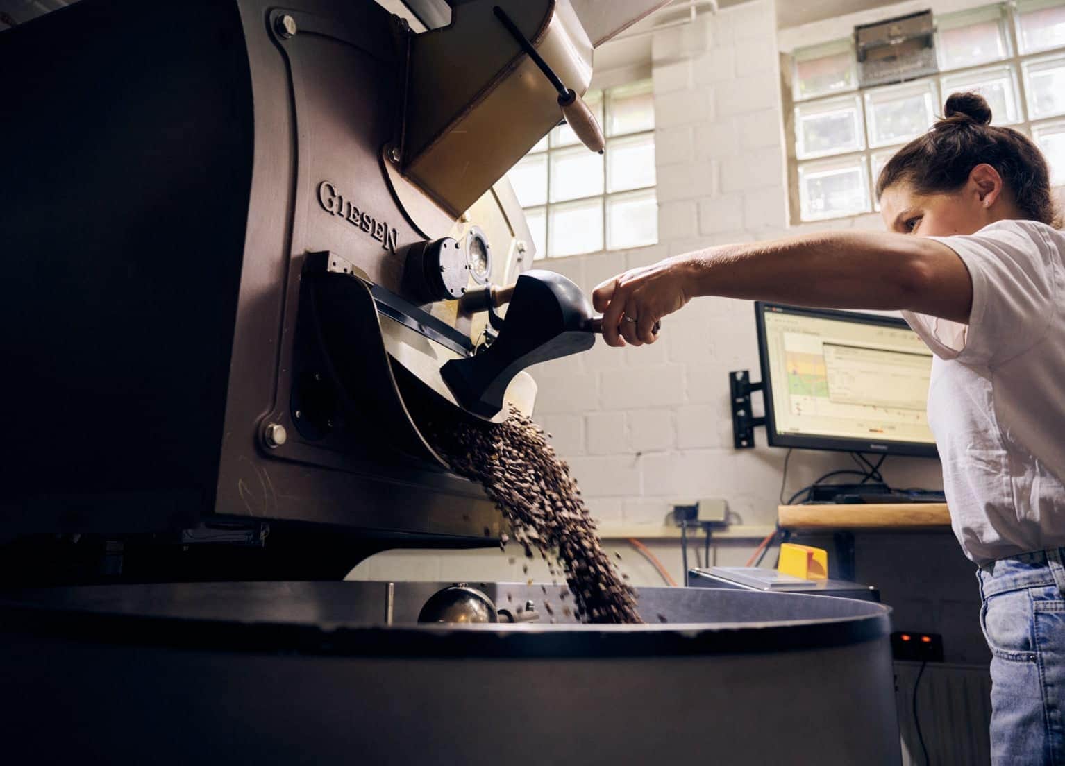 Eine Mitarbeiterin von The Coffee Board füllt Kaffee ab