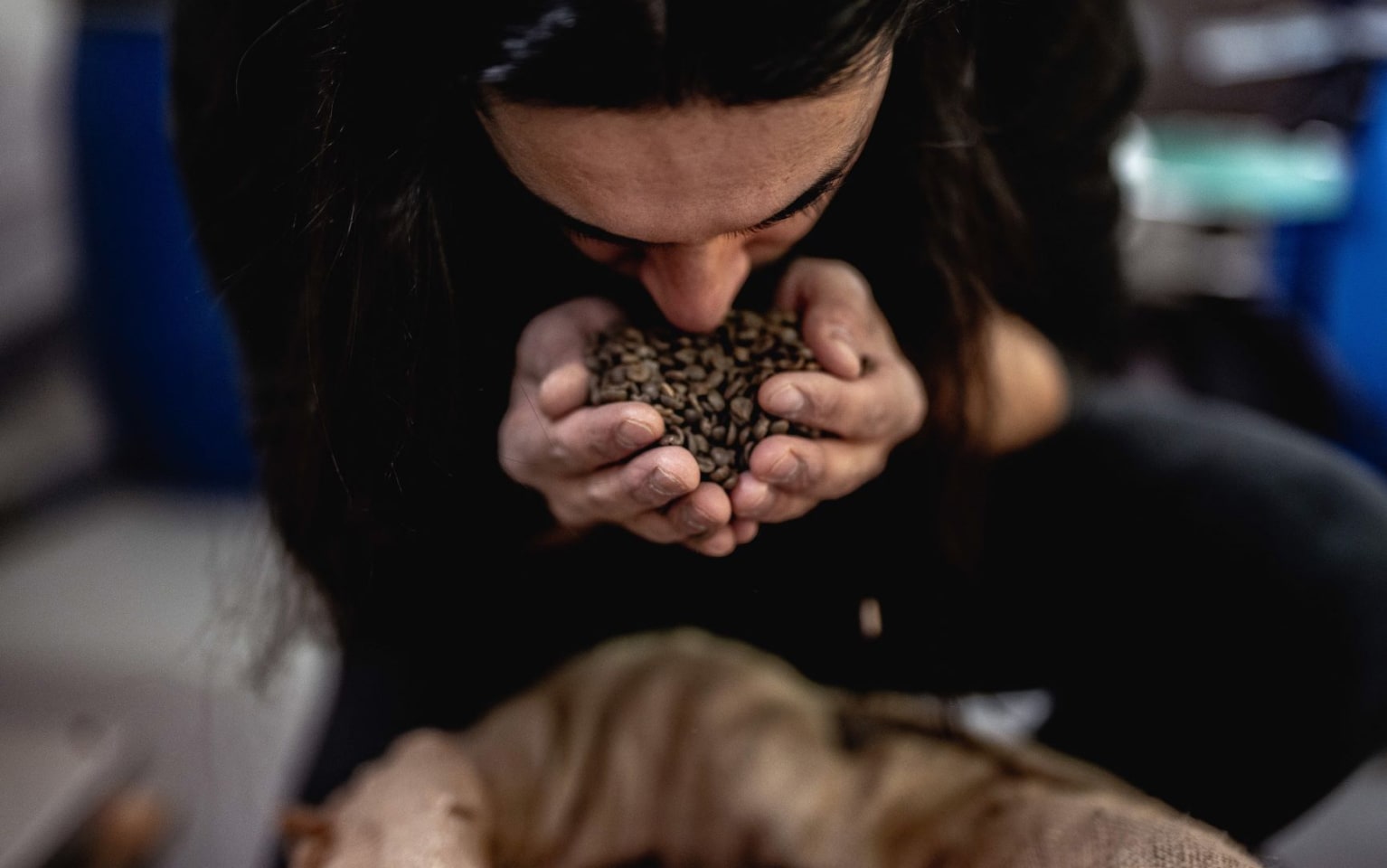 Eine Frau riecht an Kaffeebohnen