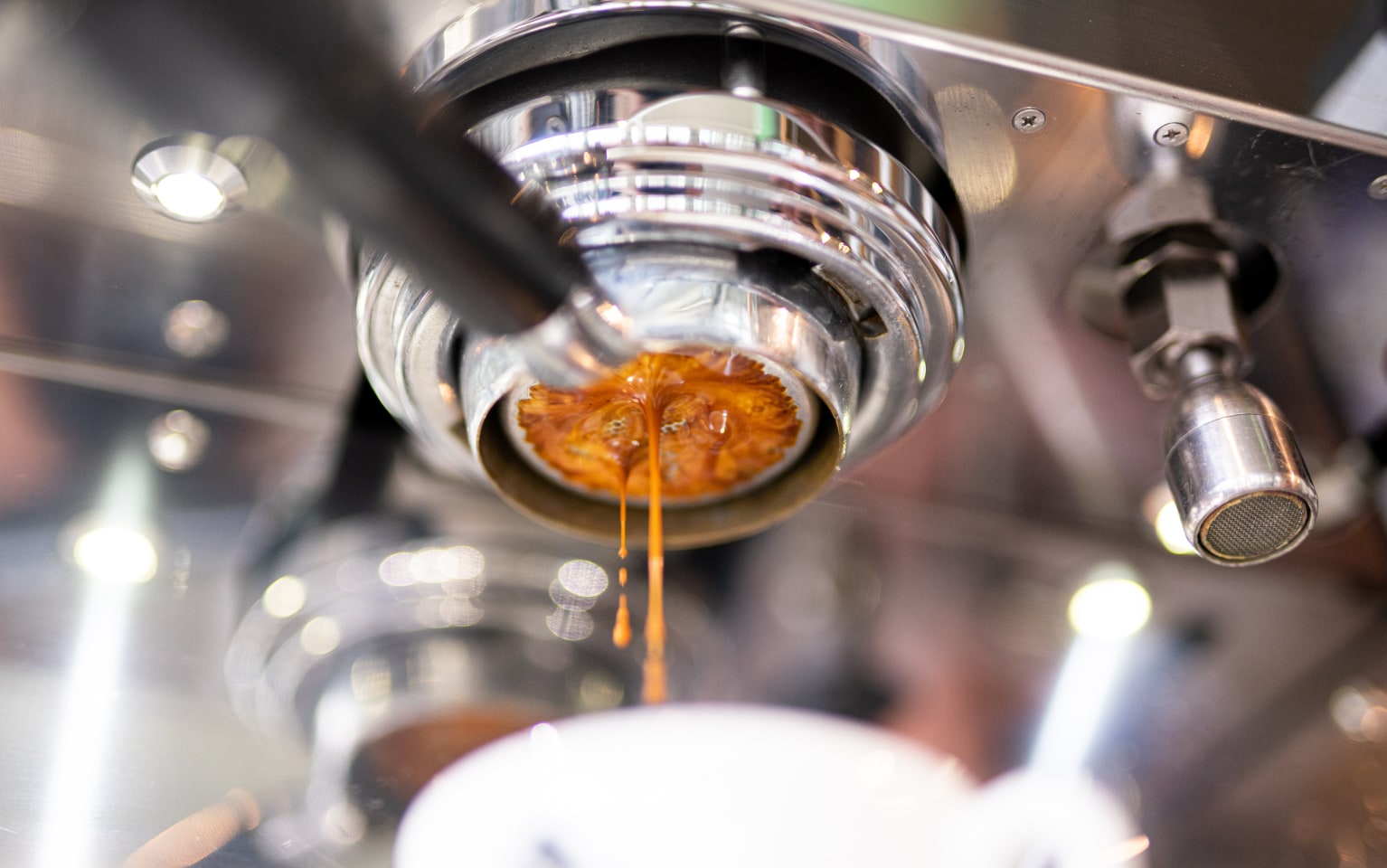 Kaffee tropft durch einen Siebträger