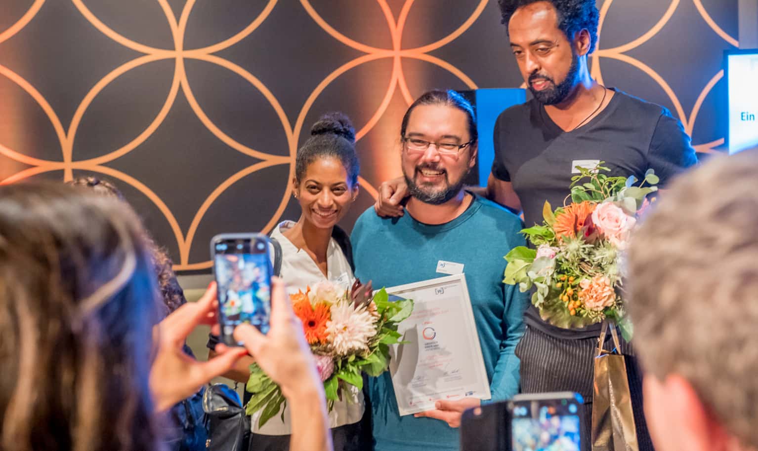 Das Team der Rösterei IMPACT COFFEE by Plastic2Beans posiert mit einer Urkunde