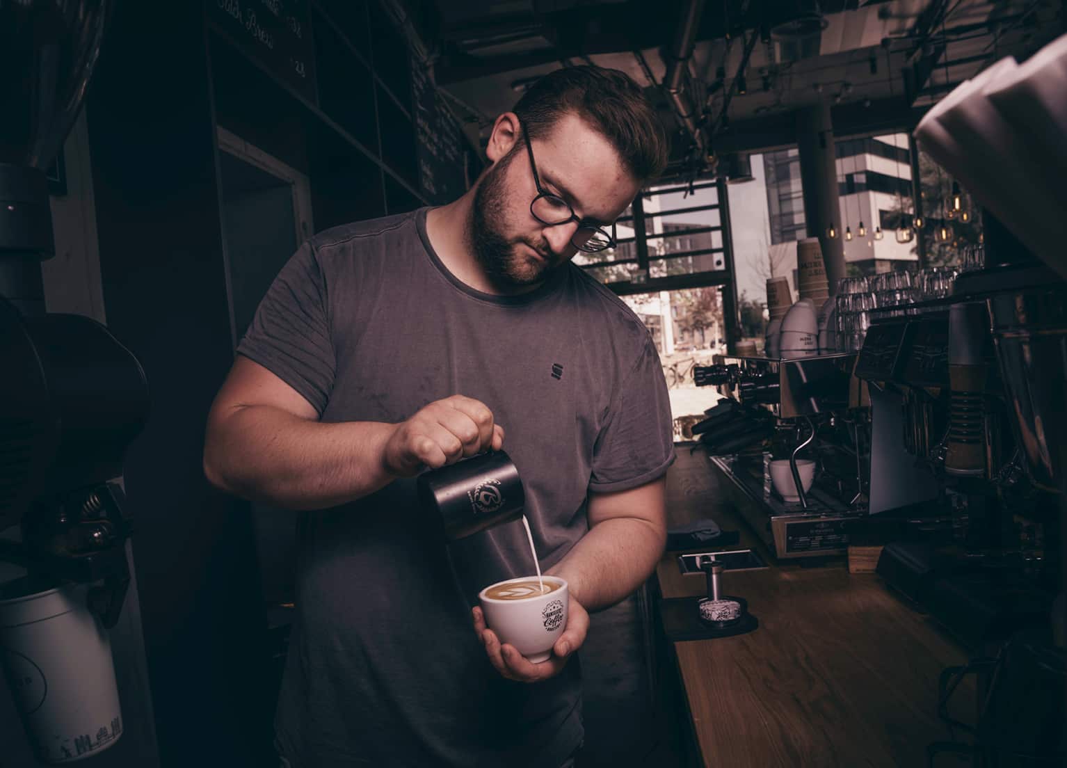 Co-Founder Frederic beim Eingießen von Milch in einen Cappuccino