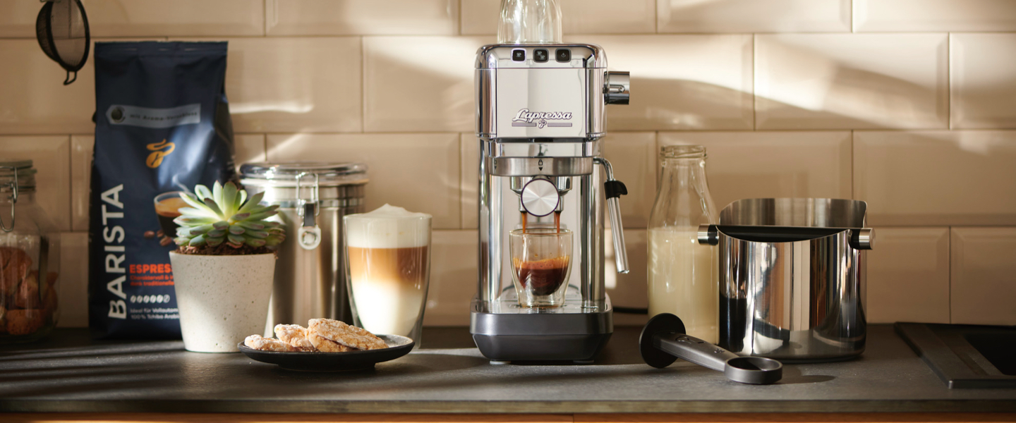 Stimmungsvolles Bild einer Siebträgermaschine und zwei Packungen Barista daneben leiten in die Welt der Siebträgermaschinen ein.